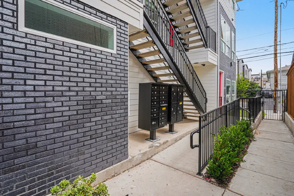 Resident walkway with mailboxes, exterior stairs, and controlled-access gates