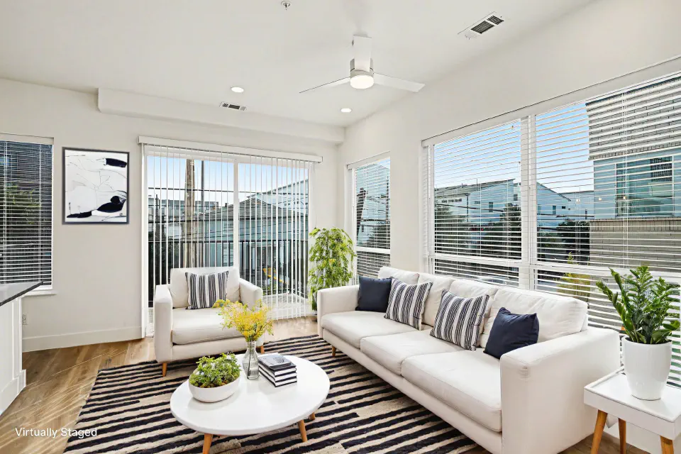 Living room surrounded by large windows with balcony access