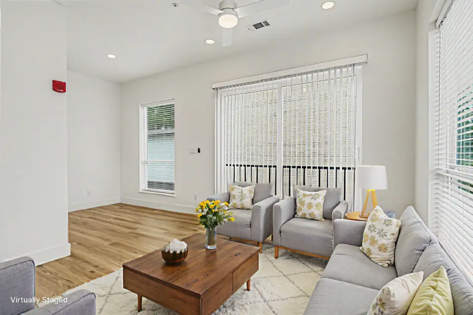 Living room with high ceilings, wood flooring, and balcony access