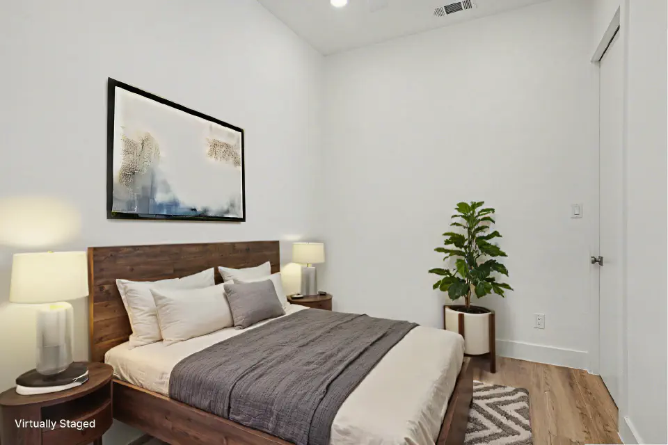 Bedroom with high ceilings, wood flooring, and a large upholstered bed