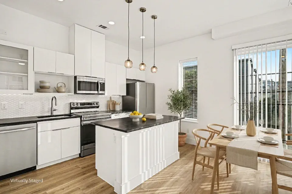 Kitchen and dining area with island, pendant lights, and large windows