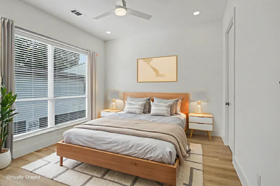 Bedroom with a large window, ceiling fan, and wood flooring